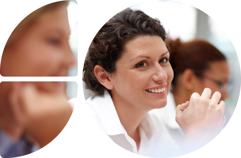 Frau sitzt mit anderen Menschen in einem Vortrag und hält ihre Hände zusammen